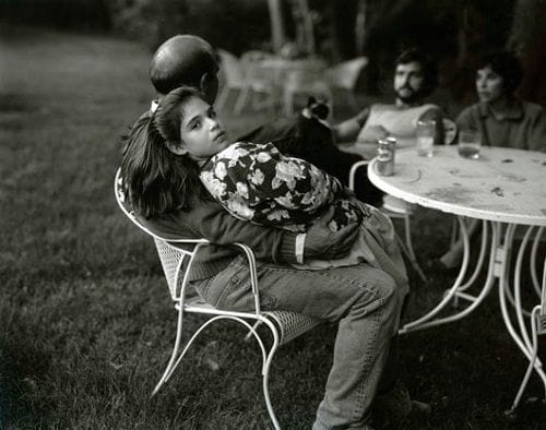 niña sentada con padre terraza