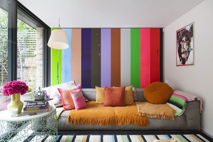 pared rayas colores con sofa marron