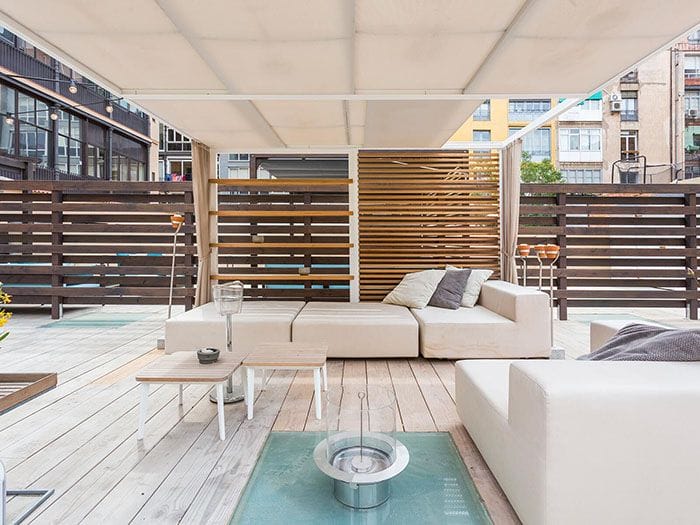 terraza con tarima de madera y sofas en atico de barcelona