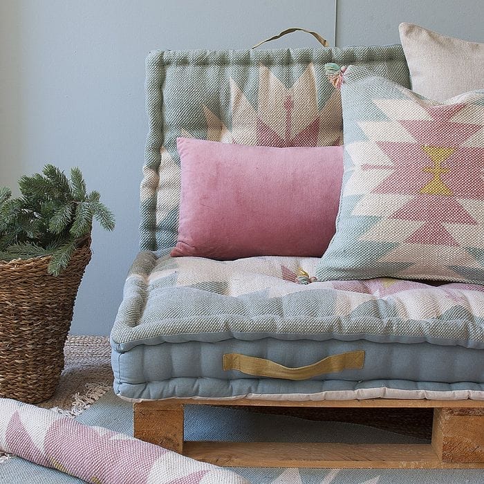 sillon pale cojines azules rosa cesto planta alfombra yute tejido