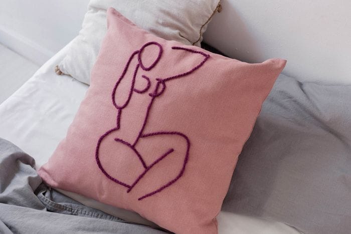 cojin rosa con bordado lila