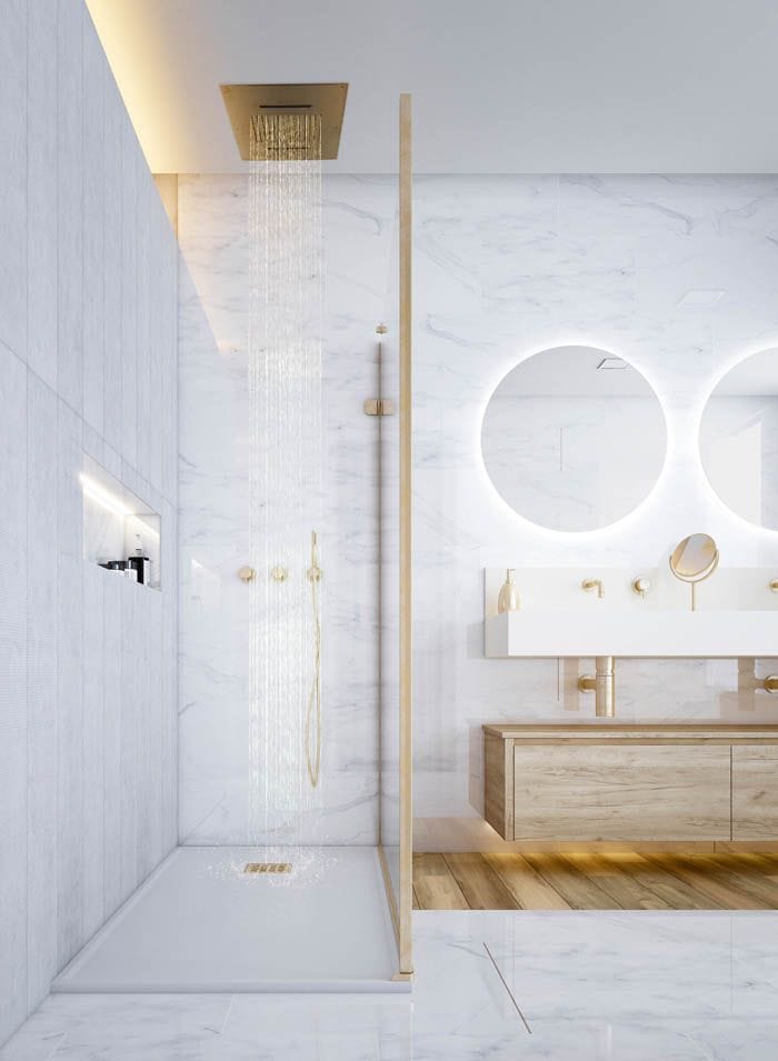 cuarto de baño dorado y marmol blanco con espejo iluminado