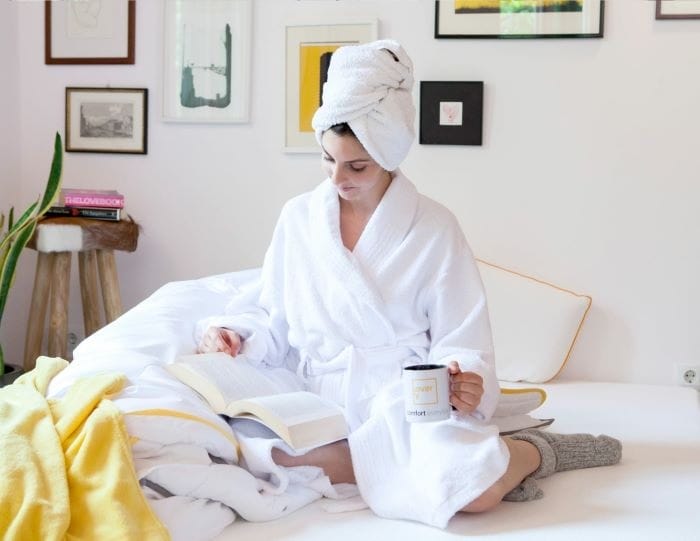 mujer con albornoz en cama