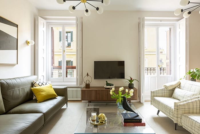 sofa oscuro y butacas cuadros claras salon mid century modern