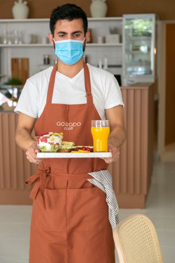 Camarero con bandeja en cafetería Agrado