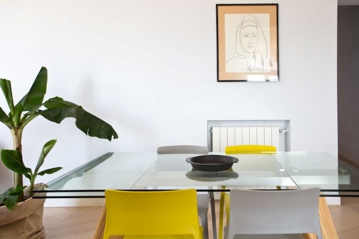 Mesa de salón con sillas amarillas y tono gris en el salón