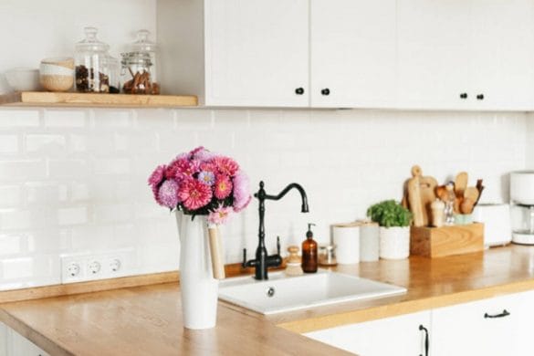 Diseño sostenible en la cocina con plantas y utensilios de madera y cristal