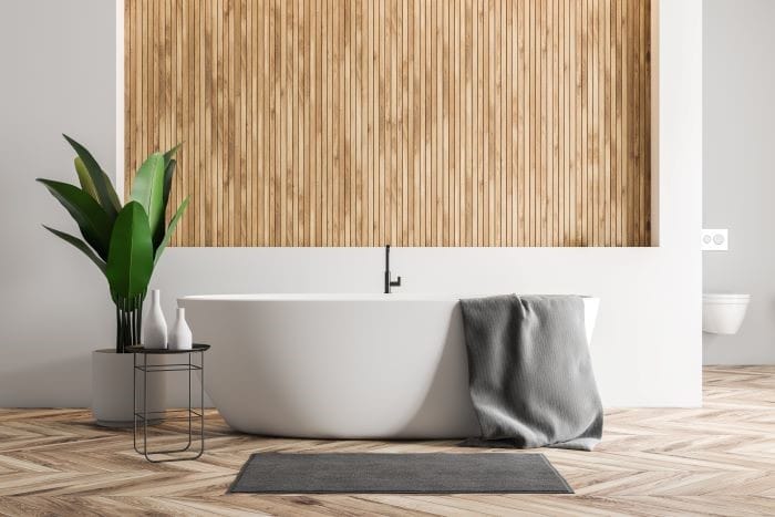 baño con bañera y paredes de madera ManoMano