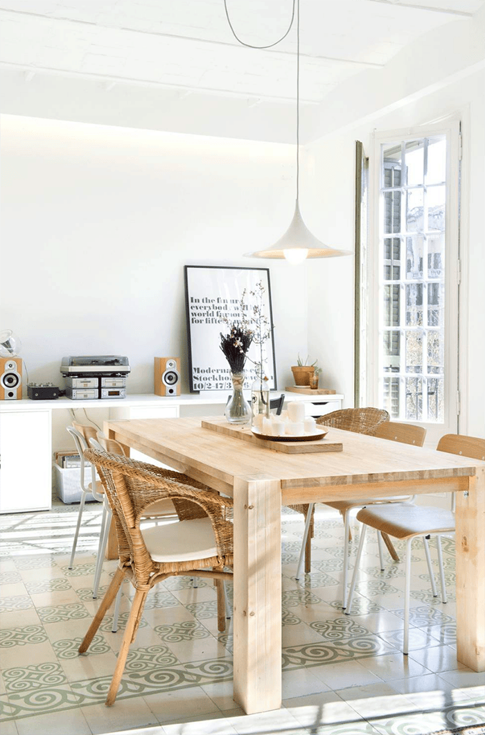 Comedor luminoso al estilo mediterráneo nórdico con mesa y sillas de madera y luz natural