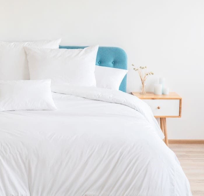 cama en dormitorio de leroy merlín con edredón y cojines