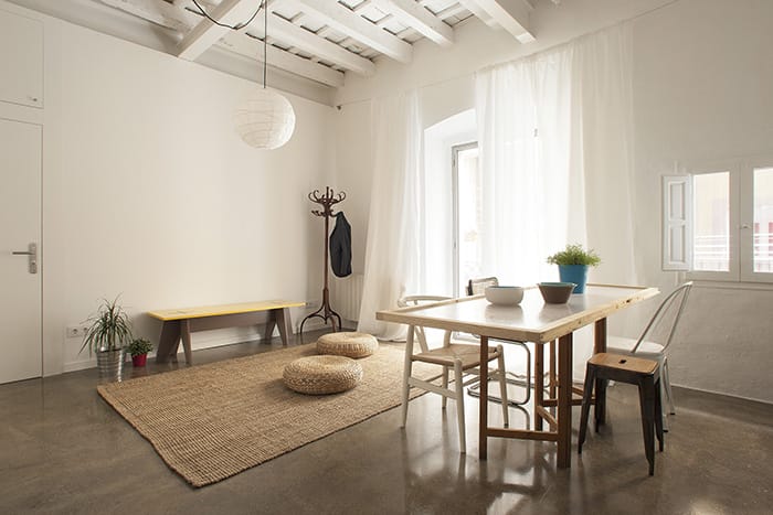 Salón luminoso y decorado al estilo nórdico mediterráneo, propio del proyecto Twin House por Nook Architects