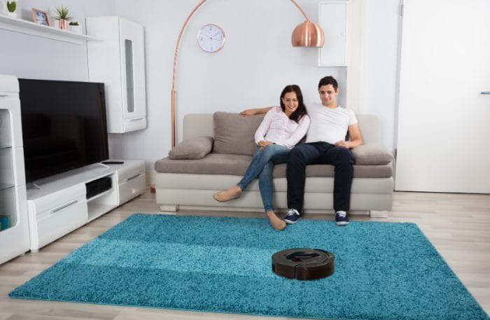 Pareja-con-robot-aspirador-en-su-hogar