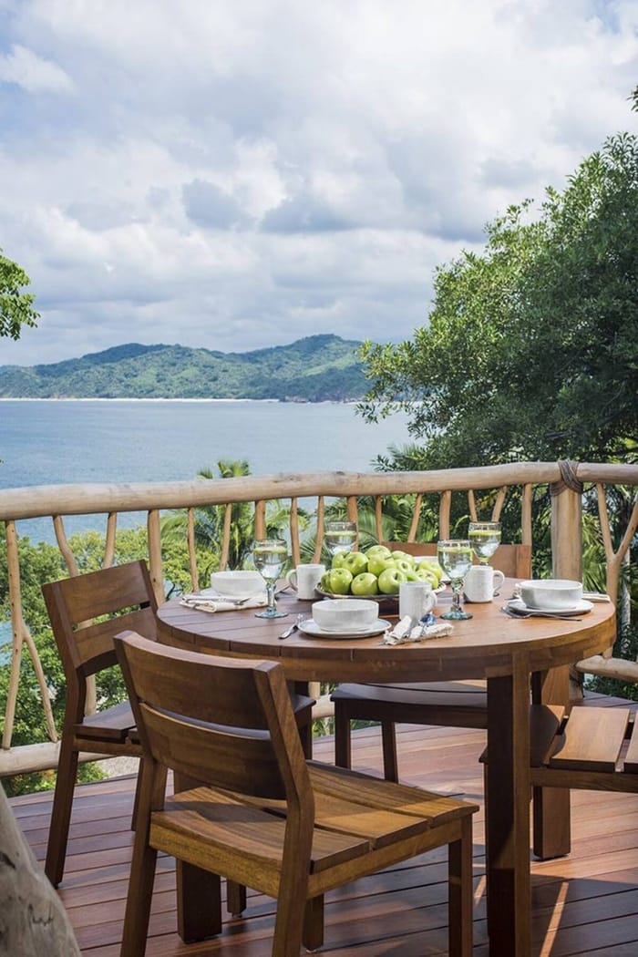 Pequeña terraza con una mesa y dos sillas con vistas al mar en Tree House, alojamiento de Airbnb en México