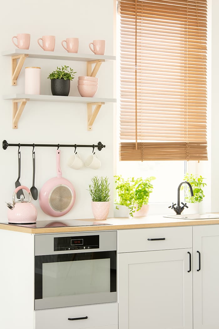 pequeña cocina con objetos organizados por color rosa