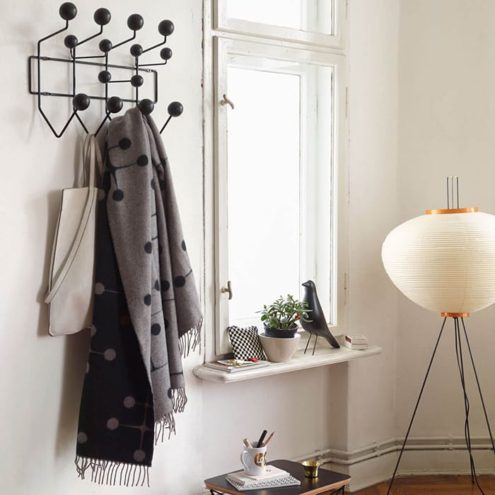 Perchero colorido Hang it all por Ray & Charles Eames en la pared a la entrada de una casa