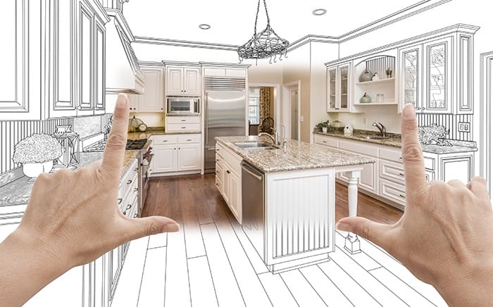 manos que dibujan en un cuadrado un diseño de cocina imaginario a partir de un plano