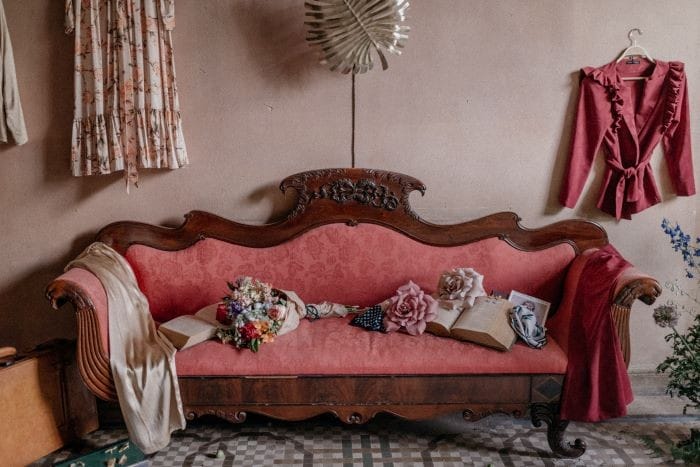 Complementos de la invitada de la boda sobre sofá rojo