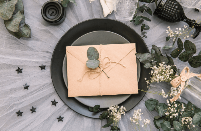 Invitación de boda encima de plato y mesa decorada