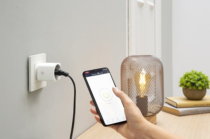 Teléfono móvil cargándose desde un enchufe modelo eco sostenible de Leroy Merlin