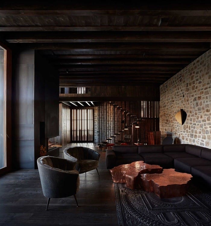 salón con un gran sofá clásico en contraste con lo demás más natural