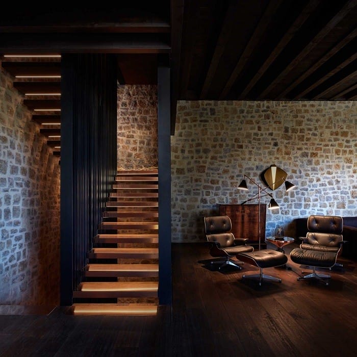 zona de lectura con dos sillones y una lámpara al lado de la escalera