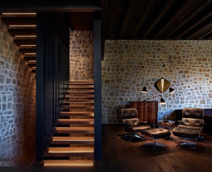 zona de lectura con dos sillones y una lámpara al lado de la escalera