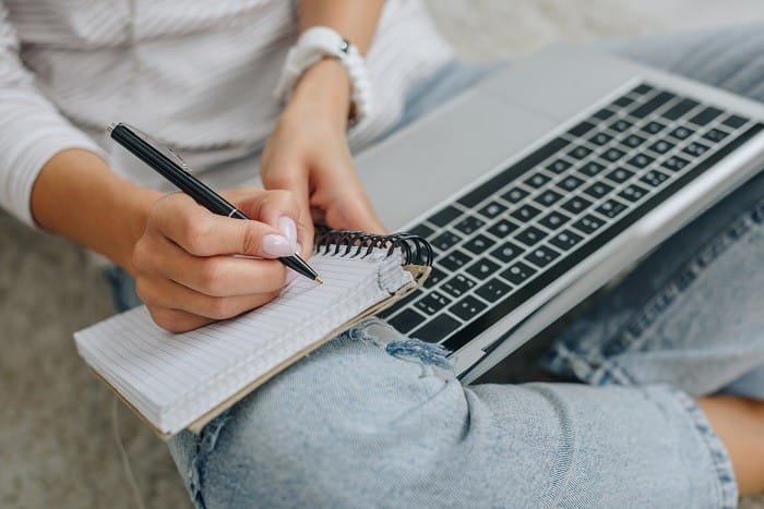 Mujer tomando nota en un curso online