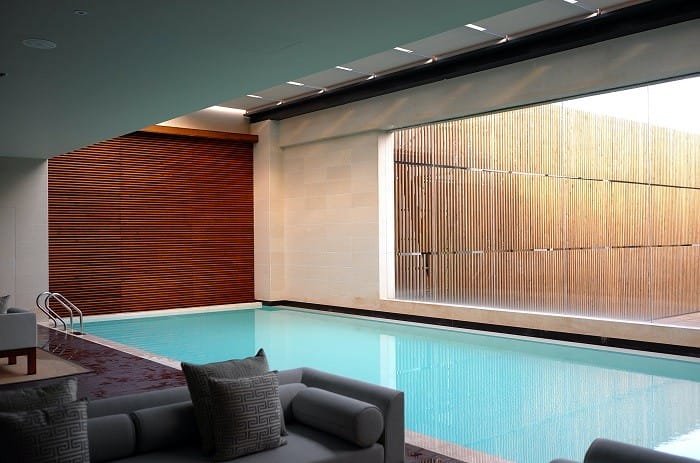 Piscina de un balneario con sofás con cojines