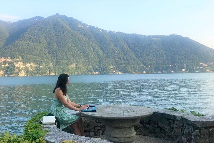 mujer teletrabajando cerca del mar