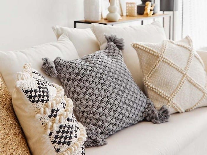 diferentes tipos de cojines de Westwing encima de un sofá