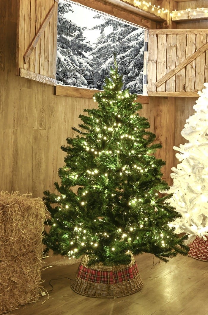 casa de madera con un árbol de Navidad con luces de Leroy Merlin