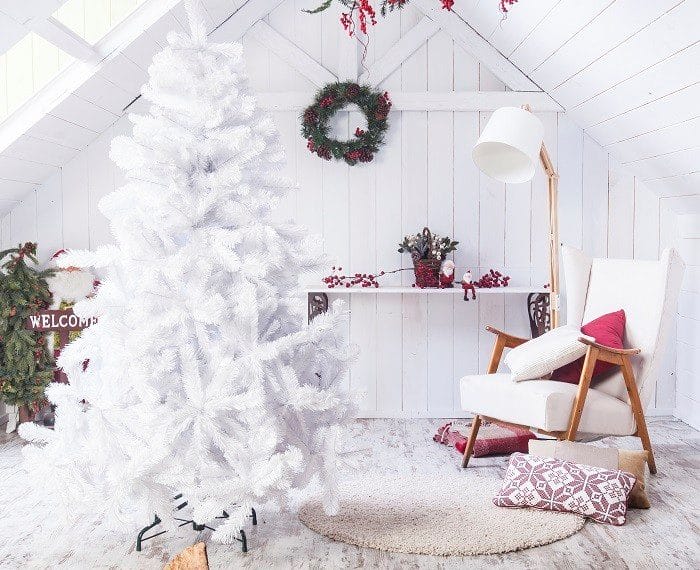 Espacio con un árbol de Navidad y decoración navideña en blanco y rojo