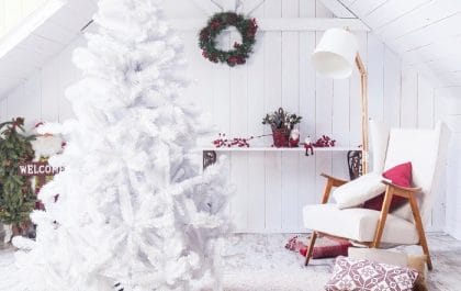 Espacio con un árbol de Navidad y decoración navideña en blanco y rojo