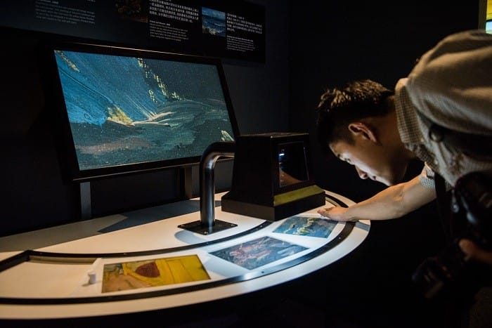 chico mirando por un microscopio los cuadros de van gogh