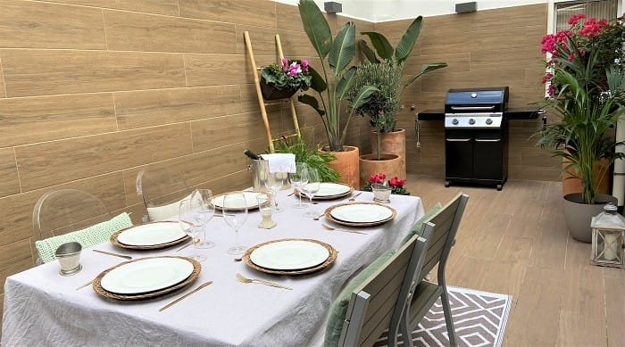 patio con mesa, plantas y barbacoa de diseño