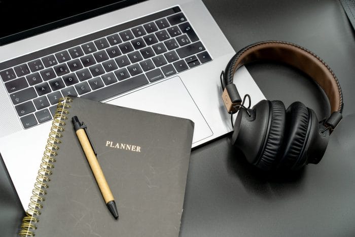 Portatil con cascos y una agenda para organizarse