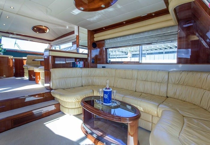 Interior de un yate de alquiler con sofá y champagne