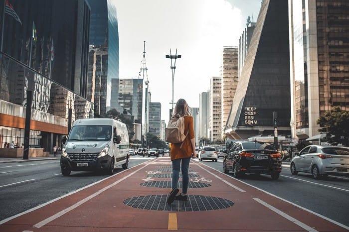 Mujer con mochila sola en la ciudad