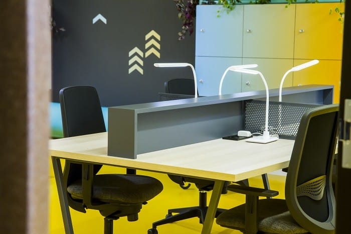 mesa con lámparas y separadores de un coworking