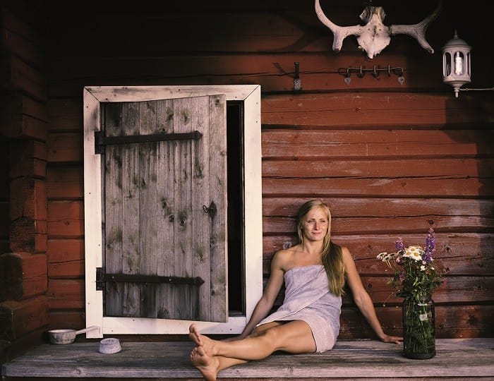 mujer sentada en la entrada a una sauna