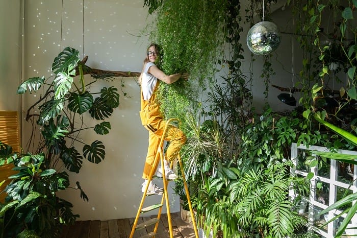mujer queriendo a sus plantas y cuidándolas