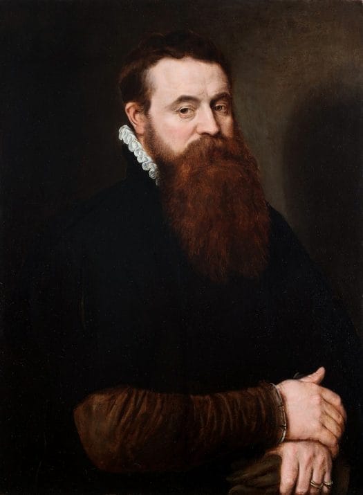 Retrato de un hombre con barba que sostiene unos guantes