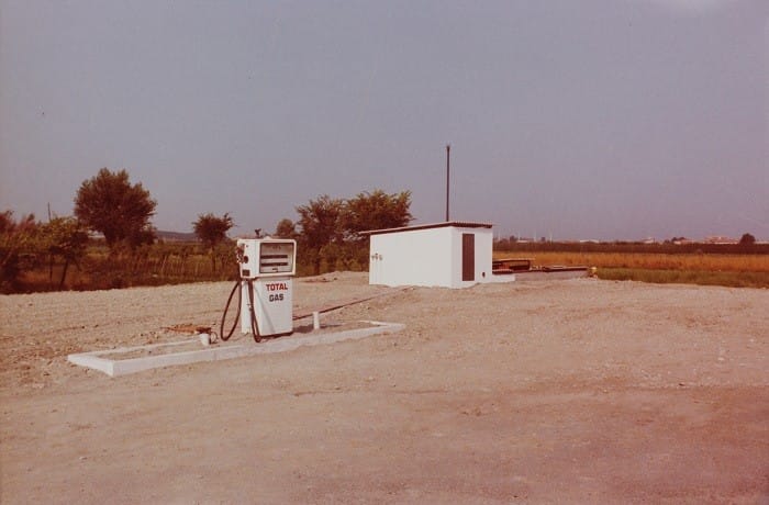 Fotografía de un campo con gasolinera antigua