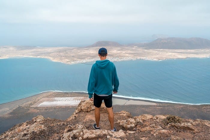 hombre en la Playa de Famara con la isla de La Graciosa de fondo