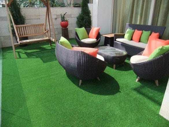 Terraza con mesa y sofás con césped artificial