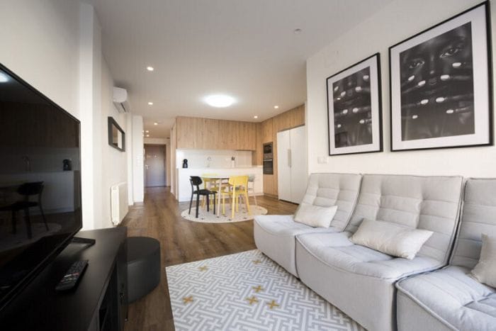 Salón con cocina integrada en coliving