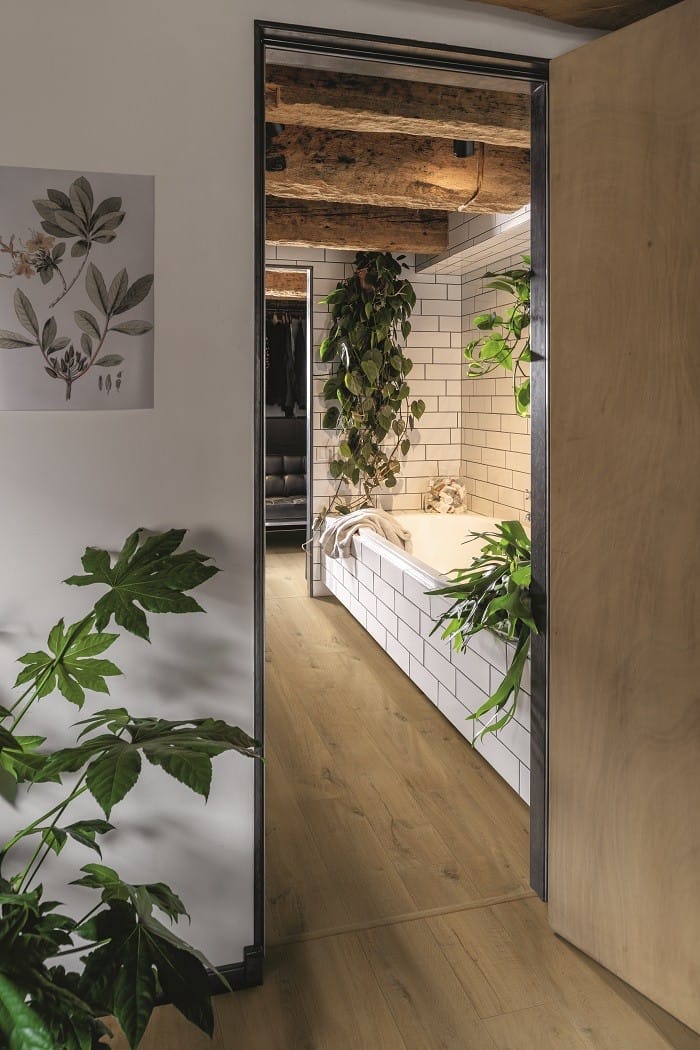 cuarto de baño con bañera y plantas de decoración