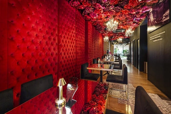 Pasillo rojo con flores en el techo de Inclán Brutal Bar