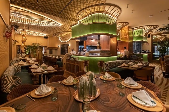 Restaurante Bakan con barra verde y mesas