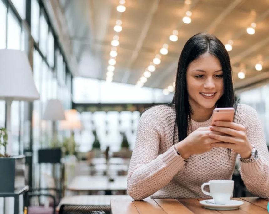 mujer con su móvil en un bar